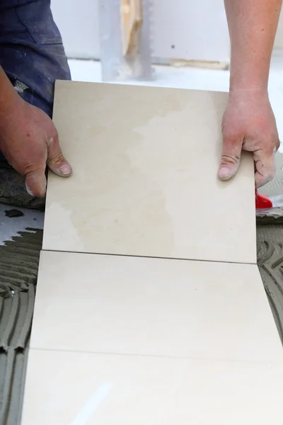 Construction worker is tiling at home, tile floor adhesive — Stock Photo, Image