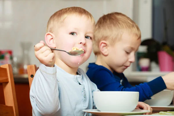 Boys kids children eating corn flakes breakfast meal at the table — Stock Photo, Image