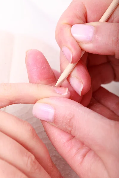 Beautician cleaning cuticles hands with cosmetic stick. Beauty spa salon — Stock Photo, Image