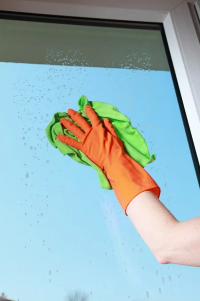 Gloved hand cleaning window with rag — Stock Photo, Image