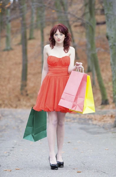 Parkta yürümek çanta ile Kırmızı elbiseli kız — Stok fotoğraf