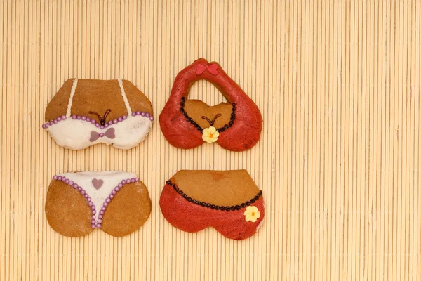 Lucu bikini berwarna-warni bentuk kue gingerbread di tikar bambu — Stok Foto