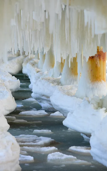 Cenário de inverno. Mar Báltico. Fechar formações de gelo icicles em postes de cais — Fotografia de Stock