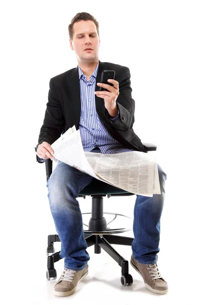 Man reads newspaper phoning - economy news — Stock Photo, Image