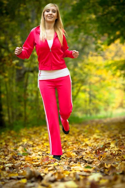 Donna che corre nella foresta autunnale. Allenamento corridore femminile . — Foto Stock