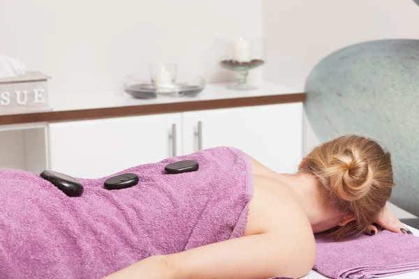 Skjønnhetssalong. Kvinne som får massasje av varm stein – stockfoto
