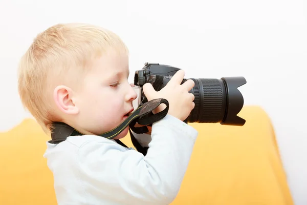 Pojke barn barn leker med kameran ta foto. Hemma. — Stockfoto