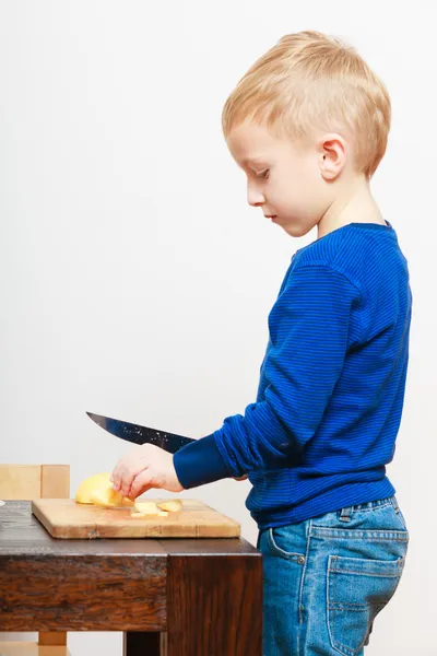 Blond boy child kid preschooler with kitchen knife cutting fruit apple — Stock Photo, Image