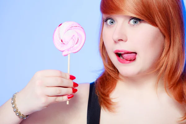 Sexy jovem mulher segurando doces. Menina ruiva comendo pirulito doce — Fotografia de Stock