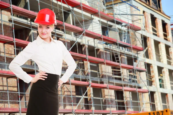 Vrouwelijke ingenieur vrouw in rode veiligheidshelm op de bouwplaats — Stockfoto