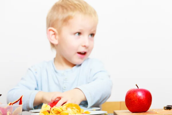Gelukkige jeugd. jongen kind kind eten apple fruit gepeld. Thuis. — Stockfoto