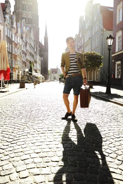 Joven hombre guapo con maleta en la calle —  Fotos de Stock