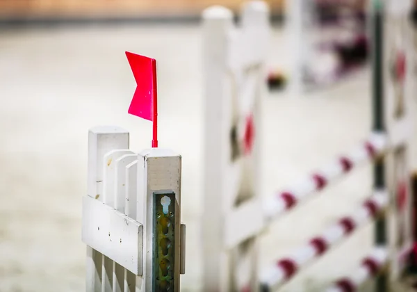 Closeup white obstacle with red flag for jumping horses. Riding competition. — Stock Photo, Image