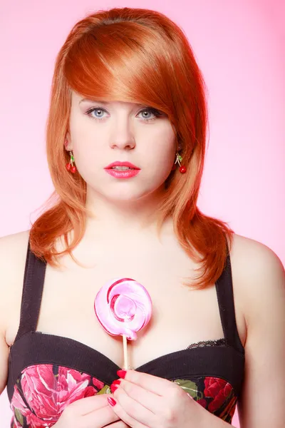 Sexy young woman holding candy. Redhair girl eating sweet lollipop — Stock Photo, Image