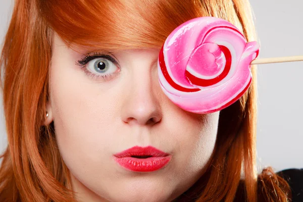 Žena hospodářství cukroví. redhair dívka s sladké lízátko srandu — Stock fotografie