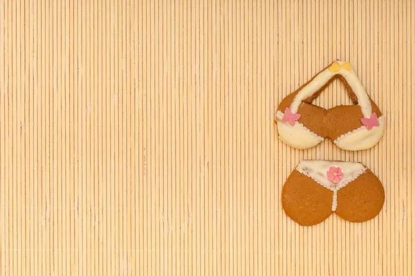黄色的粉红色比基尼形状姜饼蛋糕饼干在竹凉席上 — 图库照片