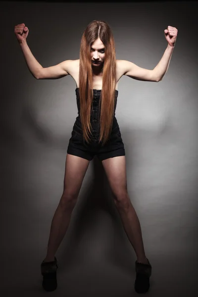 Ledsen flicka med långt hår och kreativ makeup visar hennes muskler — Stockfoto