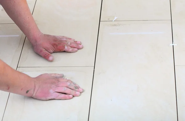 Construction worker is tiling at home, tile floor adhesive — Stock Photo, Image