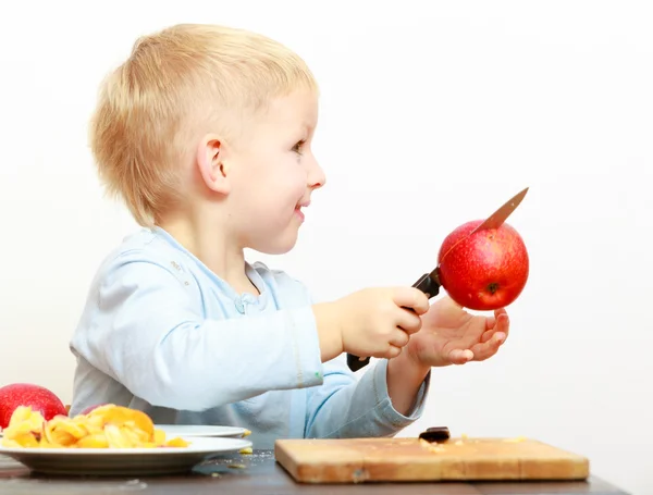 Blond boy child kid preschooler with kitchen knife cutting fruit apple — Stock Photo, Image
