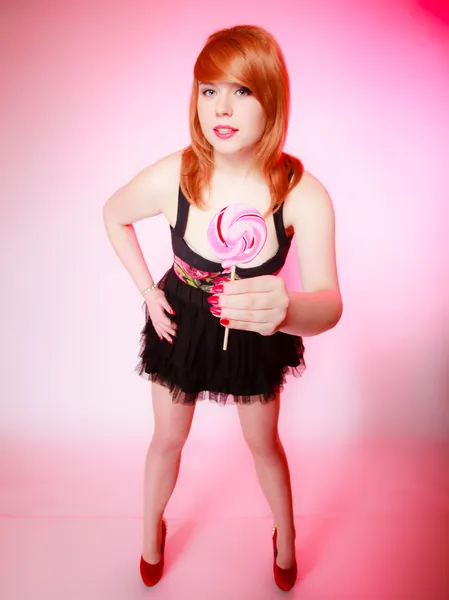 Sexy young woman showing candy. Redhair girl giving sweet lollipop — Stock Photo, Image