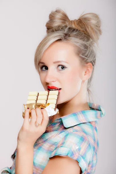 Portrait of young woman sexy girl eating chocolate on blue — Stock Photo, Image