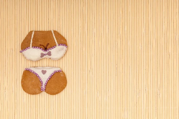 White violet bikini shape gingerbread cake cookie on bamboo mat — Stock Photo, Image