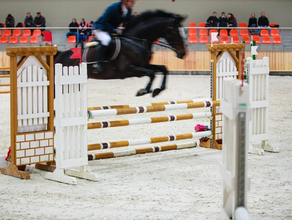 Black horse with rider jumping over obstacle. Riding competition. — Stock Photo, Image