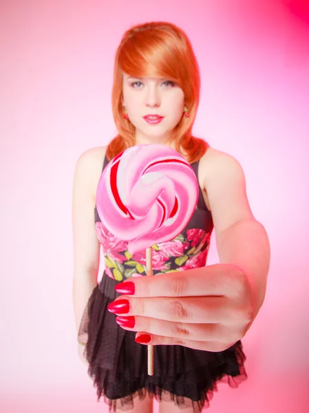 Sexy young woman showing candy. Redhair girl giving sweet lollipop — Stock Photo, Image