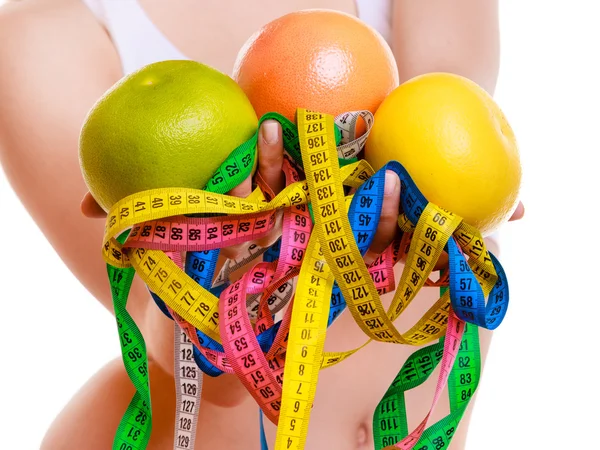Sporty fit woman with measure tapes fruit. Time for diet slimming. — Stock Photo, Image