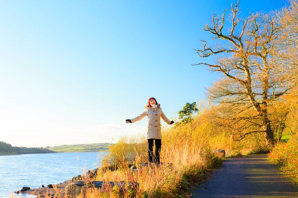 Sonbahar, nehirde rahatlatıcı yürüyen kadın. co.Cork, İngiltere. — Stok fotoğraf