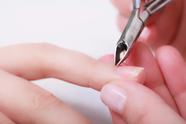 Kosmetikerin trimmt Nagelhaut einer Kundin im Schönheitssalon — Stockfoto