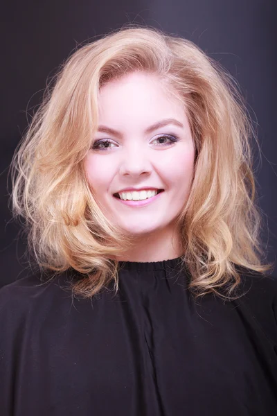Menina sorridente bonita com cabelo ondulado loiro no salão de beleza de cabeleireiro — Fotografia de Stock