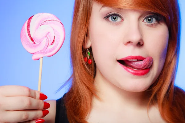 Sexy young woman holding candy. Redhair girl eating sweet lollipop — Stock Photo, Image