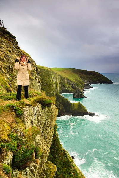 Donna in piedi sulla scogliera rocciosa vicino all'oceano Co. Cork Irlanda — Foto Stock