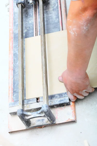 Trabajador de la construcción está cortando azulejos en casa, renovación — Foto de Stock