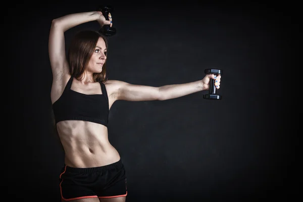 Fitness kızı omuz kaslarını çalıştırıyor dambılları kaldırıyor — Stok fotoğraf
