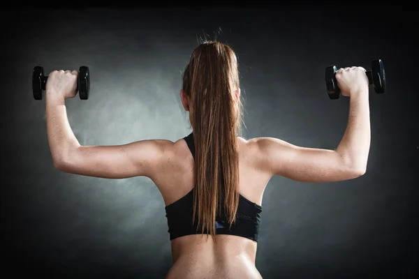 Fitness Girl trainiert Schultermuskeln beim Hantelheben Rückansicht — Stockfoto