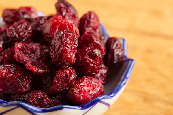 Diet healthy food. Dried cranberries in bowl on wooden table background — Stock Photo, Image