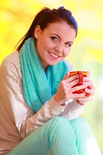 Gadis bahagia santai di taman musim gugur menikmati minuman panas — Stok Foto