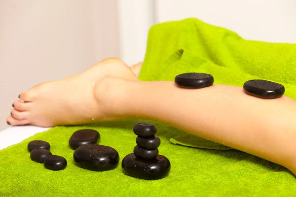 Salão de beleza. Mulher recebendo spa massagem pernas de pedra quente — Fotografia de Stock