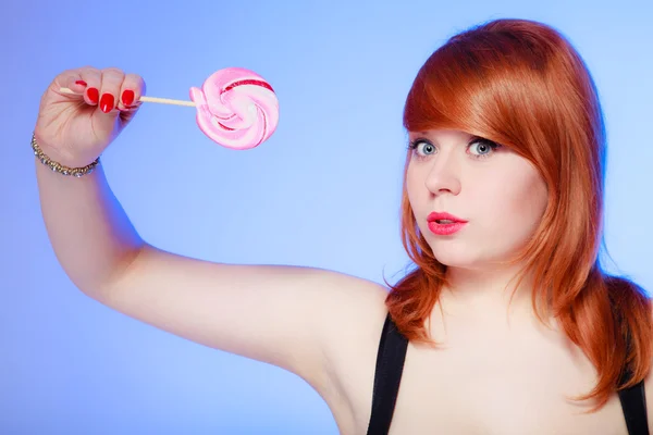 Sexy young woman holding candy. Redhair girl eating sweet lollipop — Stock Photo, Image