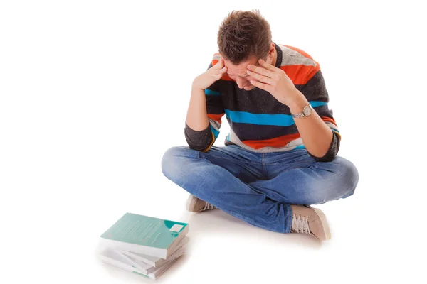 Zmęczony student z stos książek nauki do egzaminów na białym tle — Zdjęcie stockowe