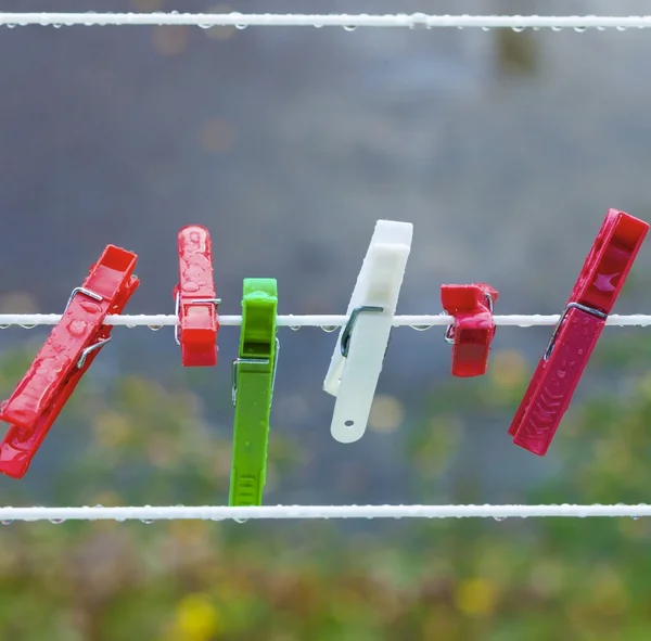 Pinzas de lavado coloridas en la tira al aire libre. Contexto. — Foto de Stock