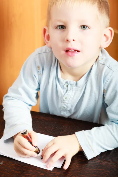 Blonde jongen kind kind tekenen met markering op stuk papier. Thuis. — Stockfoto