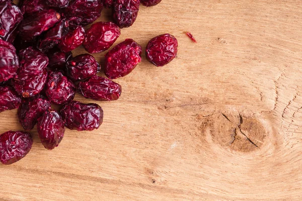 Alimentation saine alimentation. Bordure de canneberges séchées sur fond en bois — Photo