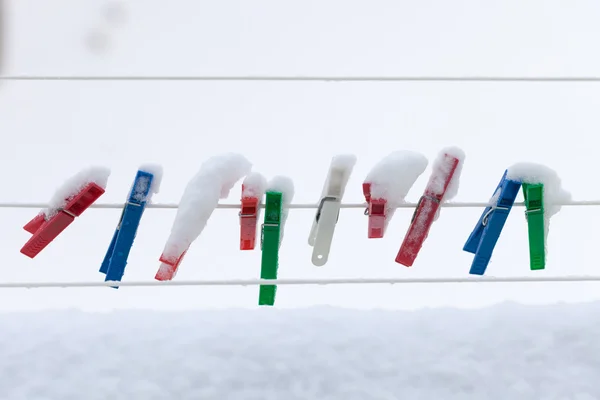 Clip colorati lavaggio biancheria coperta striscia di neve corda all'aperto. Inverno . — Foto Stock