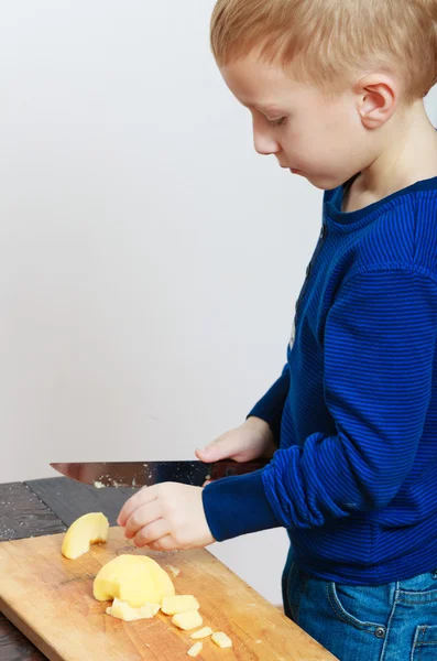 Niño rubio niño preescolar con cuchillo de cocina cortando manzana de fruta — Foto de Stock