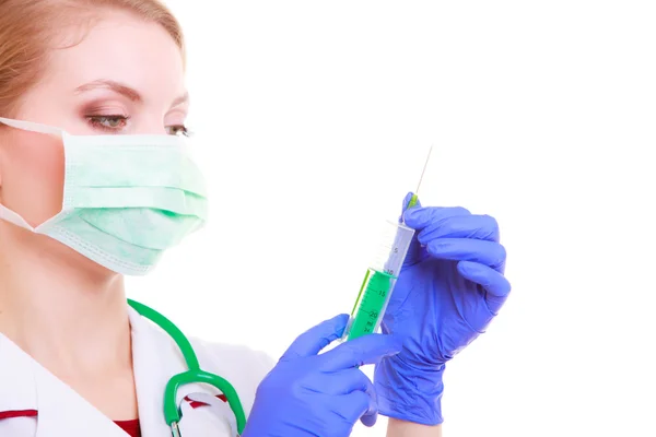 Mujer con máscara y bata de laboratorio. Médico enfermero con jeringa . — Foto de Stock