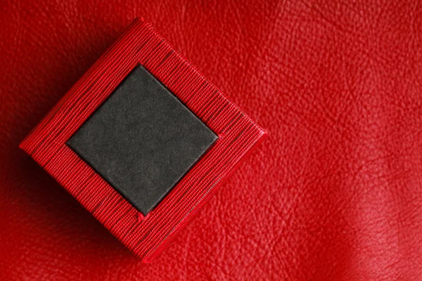 Caja de anillo rectangular negra roja sobre fondo de cuero — Foto de Stock
