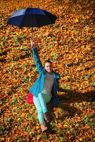 Ung flicka avkopplande med paraply i höstlig park — Stockfoto